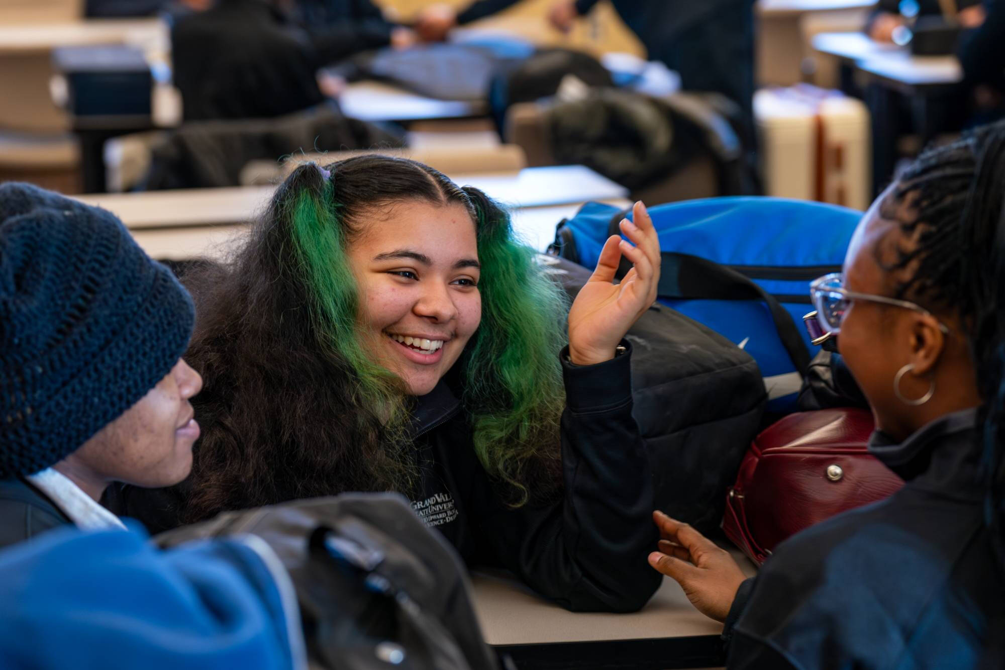 Three students laughing and talking